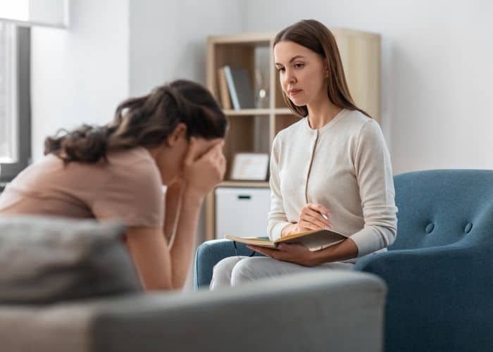 Psicóloga conversando con una paciente durante una sesión de intervención terapéutica en consulta.