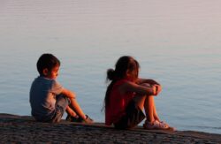 Adulto y niños compartiendo una actividad tranquila, representando la educación en el afecto, el respeto y la comunicación emocional.