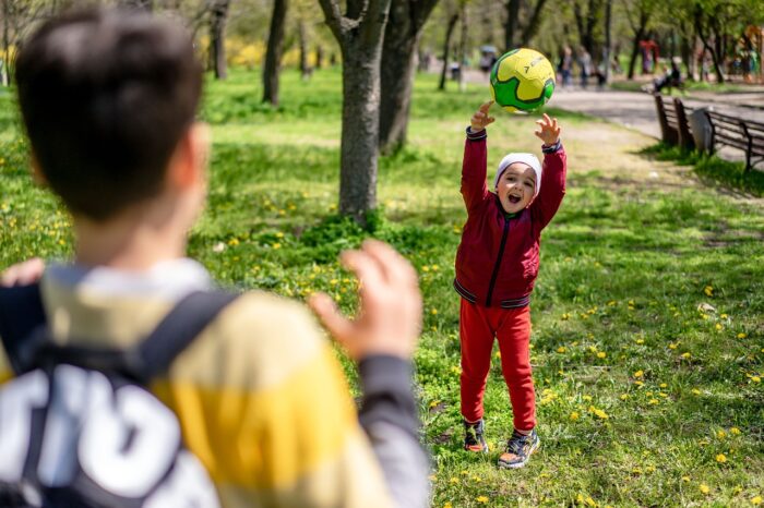 Niñas y niños jugando juntos tras un pequeño conflicto, mostrando reconciliación y vínculo afectivo en un entorno escolar o de juego.