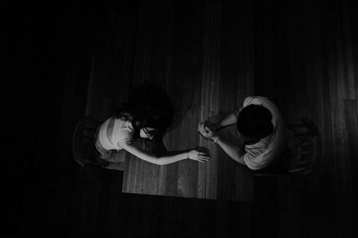 Pareja en casa mostrando cansancio y distancia emocional, reflejando el impacto de la carga mental en la relación.