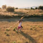 Niño y niña jugando al aire libre en primavera, mostrando energía elevada y emociones intensas.