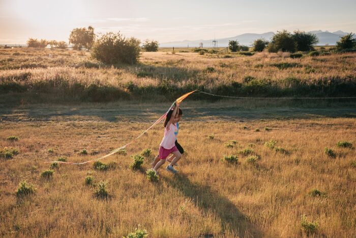 Niño y niña jugando al aire libre en primavera, mostrando energía elevada y emociones intensas.