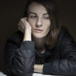Mujer visiblemente cansada sentada en silencio, representando la presión de poder con todo y el agotamiento emocional.