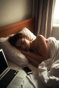 Persona acostada en cama a media tarde, luz tenue, dispositivos electrónicos apagados alrededor.